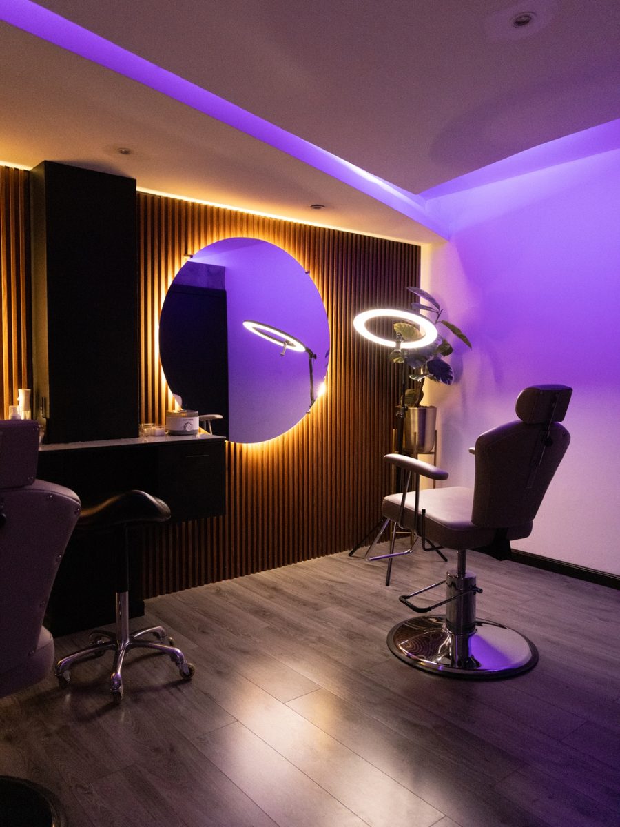 Purple-lit TEM Studio interior with brow chairs and mirrors